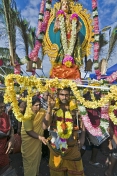 Thaipusam pilgrim with statue of Lord Murugan decorated with flowers