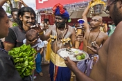 Thaipusam pilgrim anoints baby with sacred ash