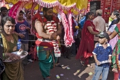 Boy looks at Thaipusam devotee with elaborate Kavadi burden