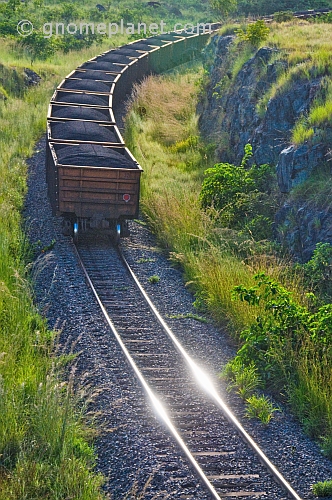 A heavily laden coal train rounds a corner at sunset in Lope National Park.