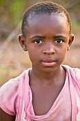 Young Gabonese girl with short hair in a light purple shirt.