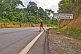 Western woman wearing shorts crosses the Equator on an open road.