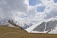 Image of Snow-covered mountains contrast the bare stone of the Tsminda Sameba Monastery.