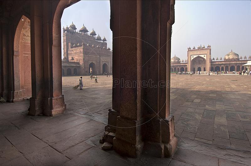 Walkway and courtyard of Akbar's Jami Masjid in early morning light.