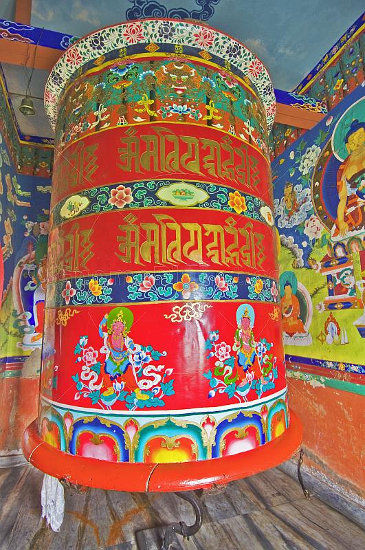 Large colorful prayer wheel in Buddhist monastery.