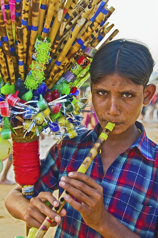 A whistle-seller demonstrates his wares on Leela Beach.