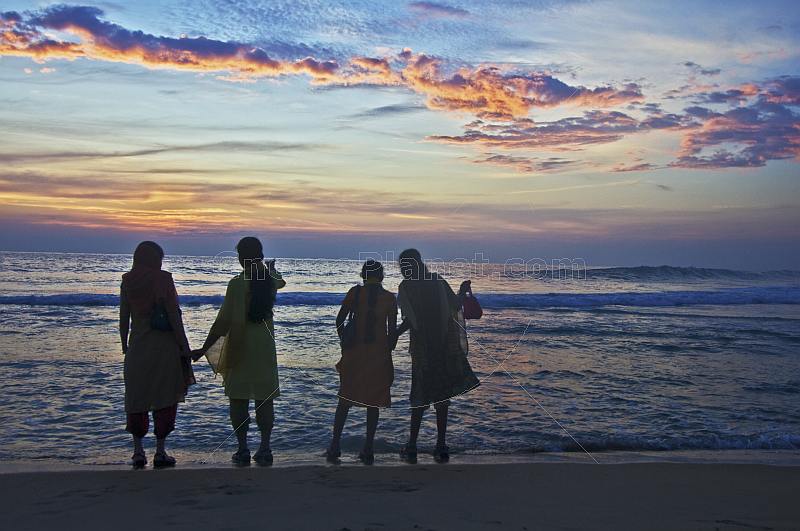 Four young Indian women watch the sunset.