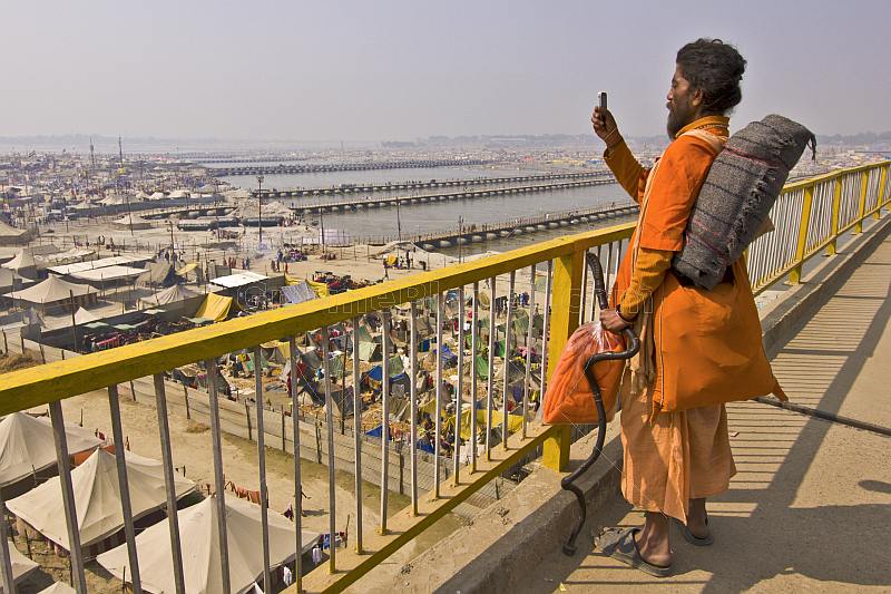 Hindu Sadhu takes photo of Kumbh Mela tents from Lal Bahadur Shastri Bridge.