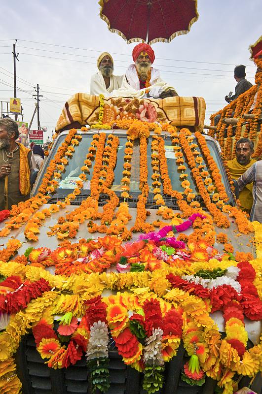 Two Holy Men on roof of flower decorated jeep for Kumbh Mela procession.