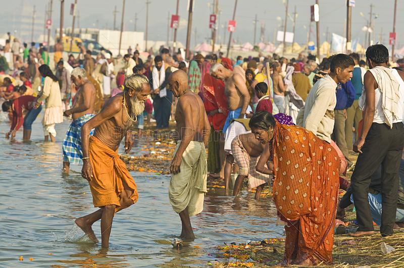 Mass crowds of Hindu pilgrims bathe in the shallows of the Ganges river Sangam.