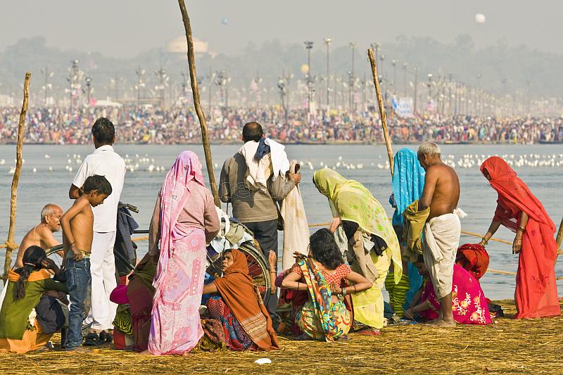 Pilgrims on east bank of Ganges watch the mass crowds bathing on the west bank.