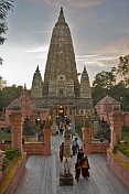 Pilgrims and monks at the entrance to the Mahabodhi Temple at sunset.
