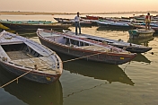 Rowing boats for pilgrims on the Ganges River at sunset.