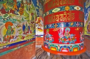 Large colorful prayer wheel in Buddhist monastery.