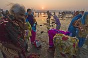 Women pilgrims prepare for ritual bathing in Ganges river at dawn.