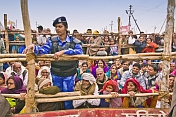 Indian police woman with patient crowds watch the Basant Panchami Snana procession.
