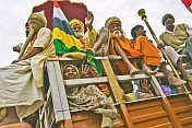 Hindu pilgrims wave from a truck in Basant Panchami Snana procession.
