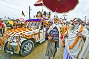 Holy Man with ceremonial umbrella walks in Basant Panchami Snana procession.