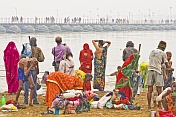 Bathers at Ganges Sangam watch pilgrims cross Ganges river on pontoon bridge.