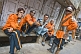 Indian bandsmen in orange uniforms.