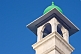White stucco minaret with green cupola.