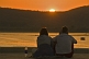 Image of Two western tourists watch the sunset over Lake Pichola.