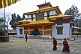 Two young Buddhist monks walk by the Enchey Monastery, built by the 8th Chogal in the 1840s.