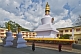 Buddhist monks walk around the gold-topped Do-drul Chorten, which contains relics and a full set of holy texts.