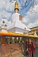 Buddhist monks walk around the gold-topped Do-drul Chorten, which contains relics and a full set of holy texts.