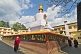 Image of Buddhist monks walk around the gold-topped Do-drul Chorten, which contains relics and a full set of holy texts.