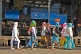 Women in headscarves walk past a Himalayan Railway steam locomotive in the engine shed.