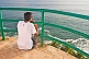A young Indian male tourist looks out to sea from the observation gallery of Vizhinjam Lighthouse.