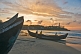 Image of Dawn rises over Lighthouse Beach as fishermen prepare their fishing boat for the morning journey.