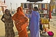 Image of Three women in saris look at necklace jewellery stall at Kumbh Mela festival.