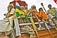 Image of Hindu pilgrims wave from a truck in Basant Panchami Snana procession.