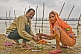 Image of Hindu pilgrim married couple perform private ceremony next to Ganges river Sangam.
