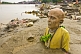 Statue Of Unknown Swami With Bald Head And Yellow Robes Buried In Ganges Mud