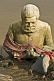 White Marble Statue Of Unknown Swami Peers Out From The Ganges Mud