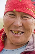 caption: Kazakh woman with red headscarf and gold teeth.