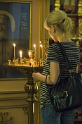 Worshipper lighting candles in front of icon at Saint Nicholas Cathedral.