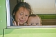 Kazakh girl and baby in a van at a village petrol filling station.