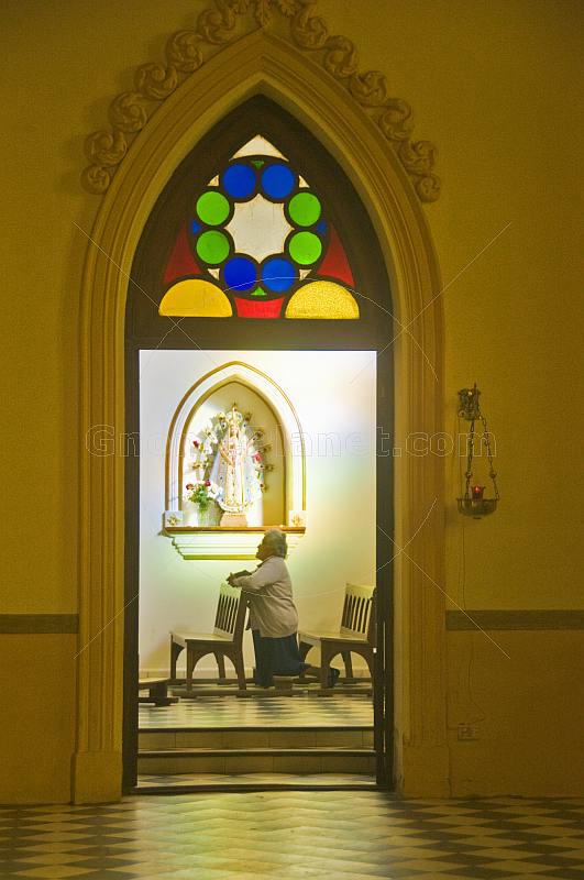 Old woman prays in a side chapel of the Cafayate Cathedral.