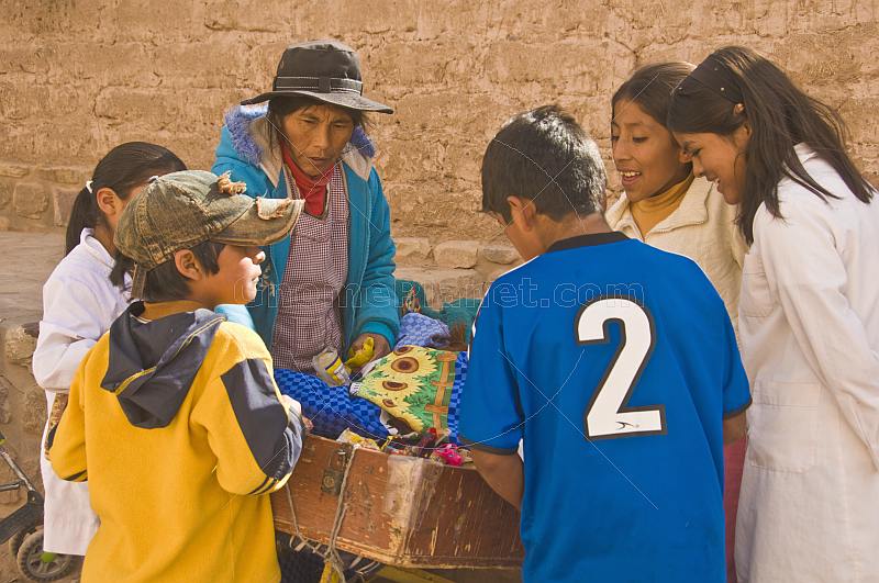 Children gather around a street pedlars stall.