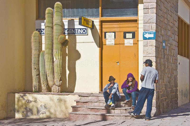 Local people sit outside the main Post Office with large cactus.