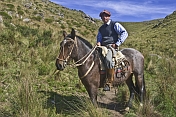 Gaucho horseman rides a brown horse at the Estancia Los Potreros.