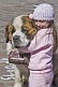 Small girl hugs huge Saint Bernard dog.