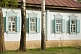 Image of Russian-style painted Cottage with shutters, decorative windows and surrounding Birch Trees.