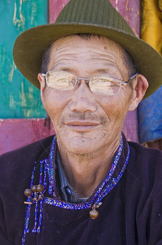 Mongolian carpenter in hat and traditional buttoned jacket.