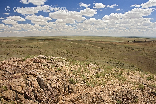 Rocks and low hills rise above the bare Mongolian plains.