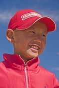 Small Mongolian boy in a red hat and jacket.